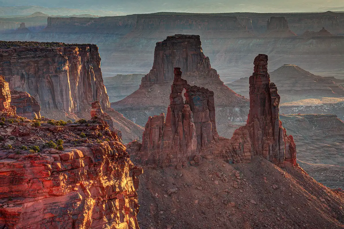 This photograph was taken from a high vantage point facing northeast and looking down on the scene just after sunrise. It was taken with a long lens and no sky is in the image. What is seen are dramatic looking buttes and mesas in the foreground and then layer after layer of buttes, ridges and mesas. Due to the angle of sunlight the layering is wonderful with each distant layer becoming lighter in tone than it's predecessor.