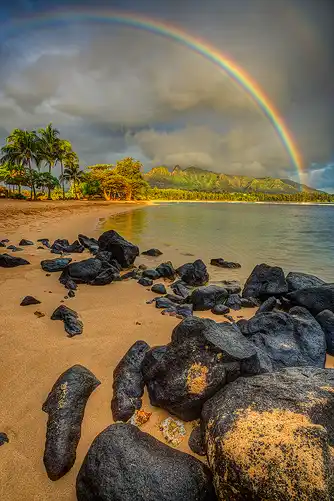 Sunrise rainbow over Anahola Beach, Kauai, Hawaii.