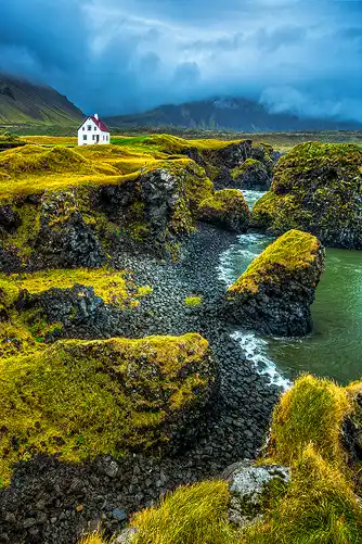 House on a cliff overlooking the ocean in Arnarstapi, Iceland.