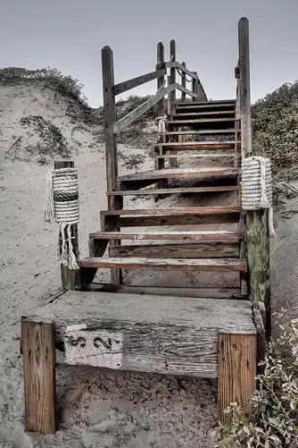 Weathered wooden stairs in beach sand dunes, Port Aransas, Texas.