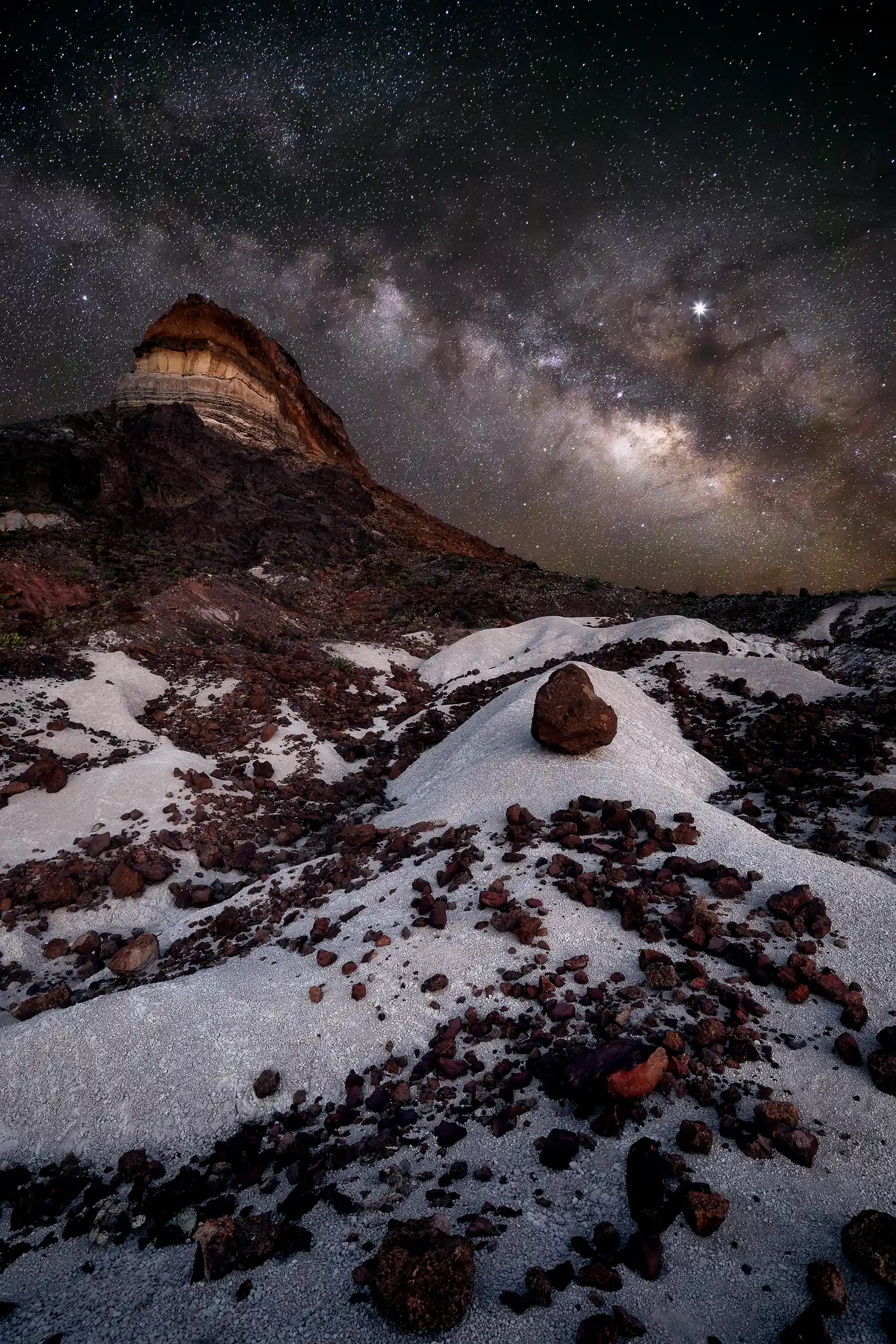 Milky Way over eroded white ash soil and Cerro Castellan in Big Bend National Park, Texas.