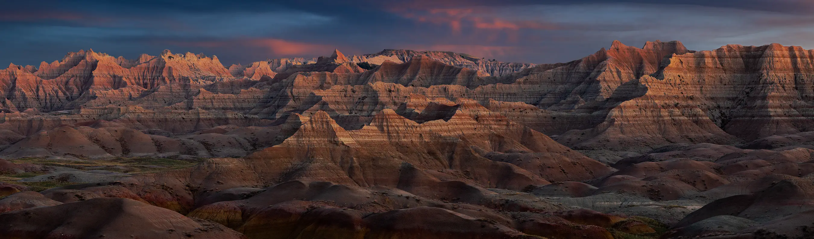 Panoramic view of layered ridges above Yellow Mounds in Badlands National Park during morning light.