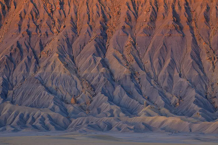 Dramatic sunrise light on intricate drainage patterns of Factory Butte, Utah.