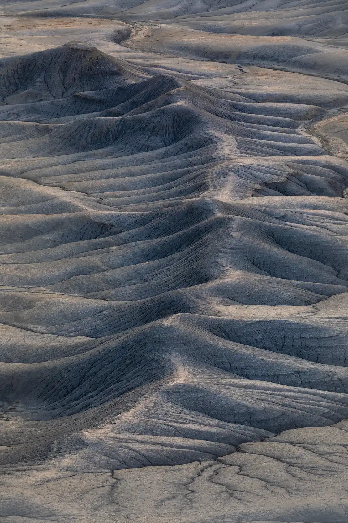 Curving ridge with ravine-cut slopes at Moonscape Overlook, Utah, resembling a backbone in the desert.