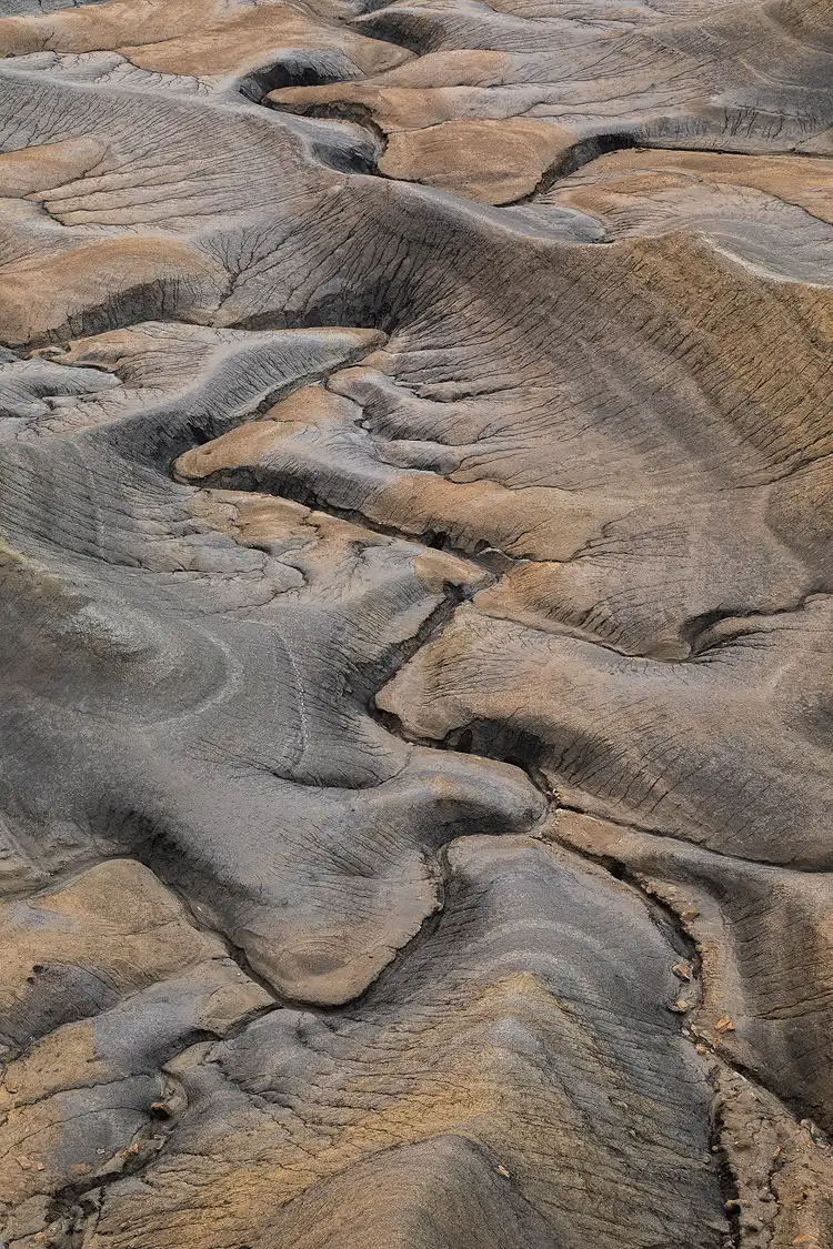 Curving drainage patterns from Moonscape Overlook, Utah, weaving through colorful desert soil in a dramatic, sky-less composition.