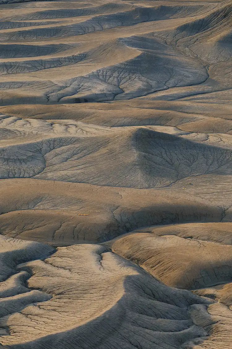 Gently rolling badlands and drainage patterns at Moonscape Overlook, Utah, captured just after sunrise under soft, diffused light.