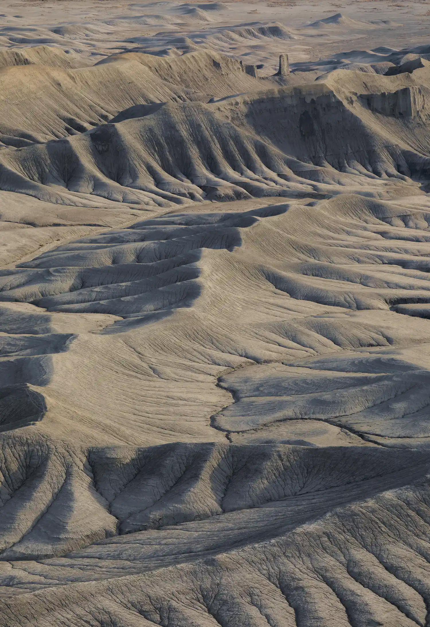 Zig-zagging ridges and ravine-carved slopes at Moonscape Overlook, Utah, lit by early morning sidelight.