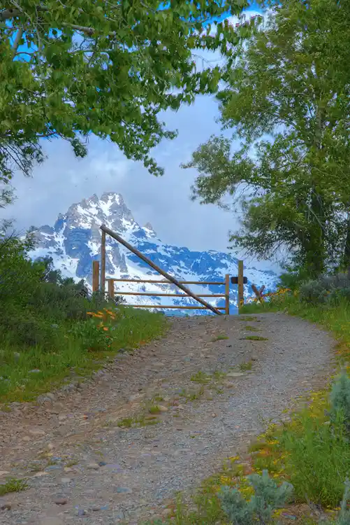Historic Bar BC Ranch gate with the Grand Teton rising beyond in Grand Teton National Park.