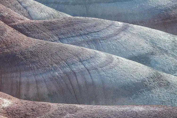 Soft morning light revealing the smooth, rolling Bentonite Hills near Hanksville, Utah.