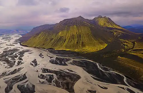 Aerial view of braided river, green mountain, Iceland. Drone photo by Robert Hawkins.