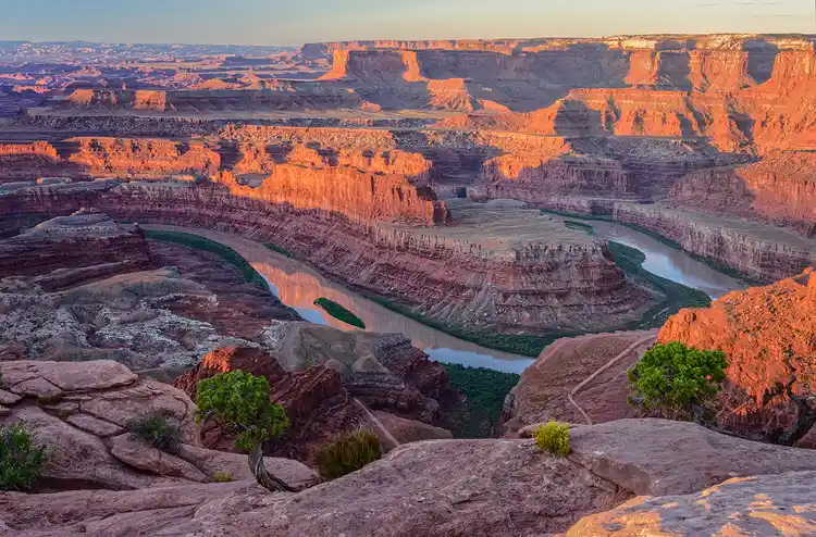 Morning light illuminating canyon walls as the Colorado River curves below Deadhorse Point State Park.