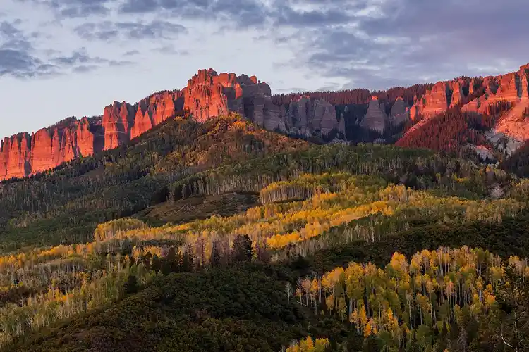 Evening light on the cliffs above golden aspens at Owl Creek Pass in the San Juan Mountains of Colorado.