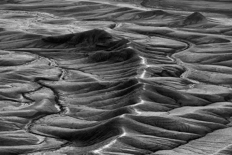 Sunlit ridge winding through finely eroded badlands at Moonscape Overlook near Hanksville, Utah.