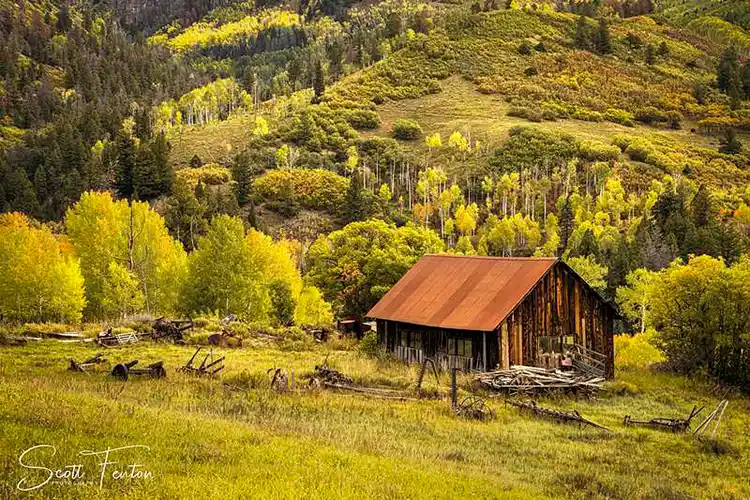 Weathered barn surrounded by golden aspens along Last Dollar Road in the San Juan Mountains of Colorado.