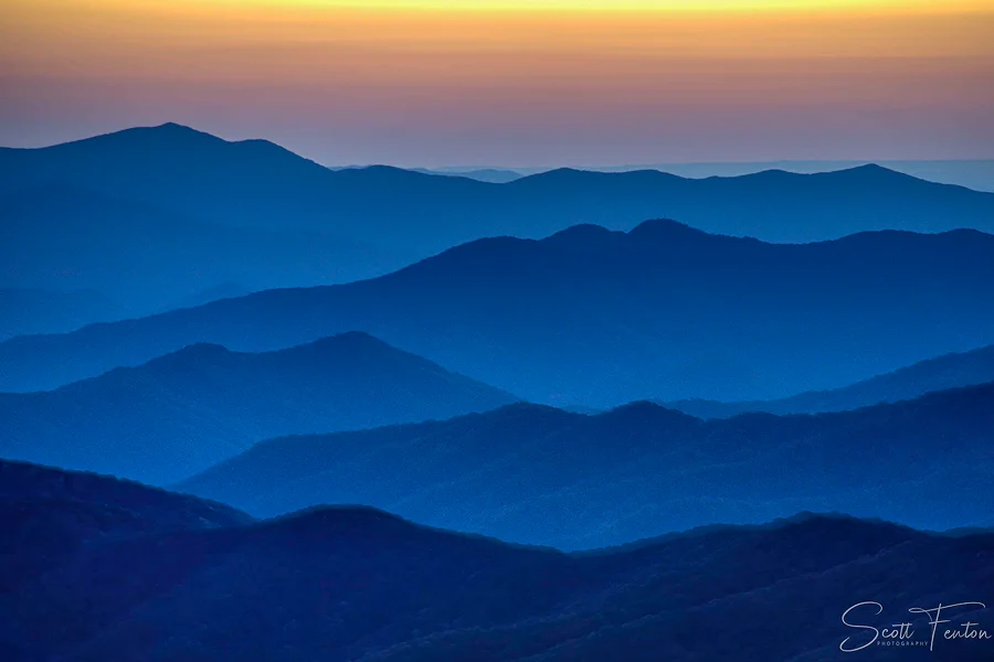 Layered mountain ridges fading into the distance beneath a colorful sunset in Great Smoky Mountains National Park.
