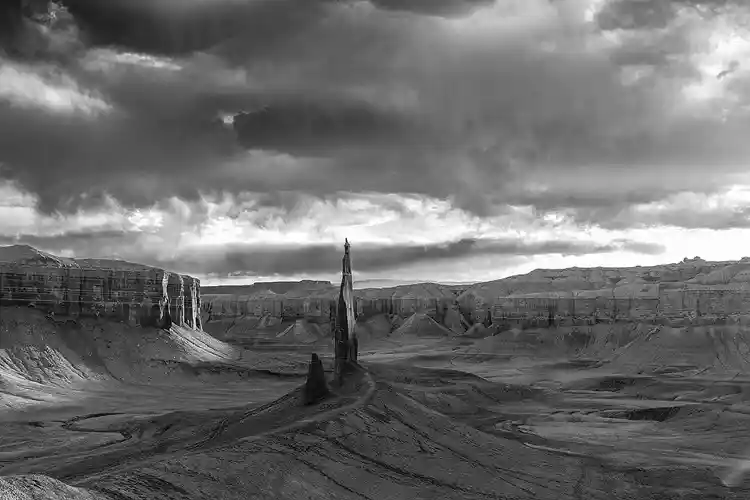 Dark storm clouds looming above Long Dong Silver in the eroded badlands near Hanksville, Utah.