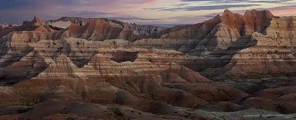 Predawn panorama of ridges and peaks made of red and white sedimentary layers at Yellow Mounds Viewpoint, Badlands National Park. Photo by George Casey.