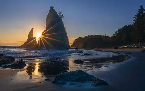 Rialto Beach sunset, sunstar between offshore rocks, Olympic National Park. Photo by Donna Pyle.