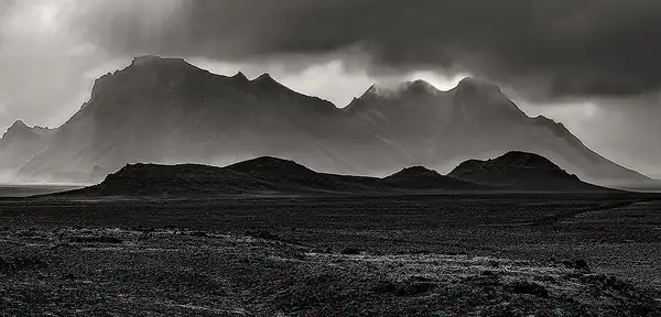 Black and white, stormy clouds, mountain light rays, Iceland. Photo by Robert Hawkins.