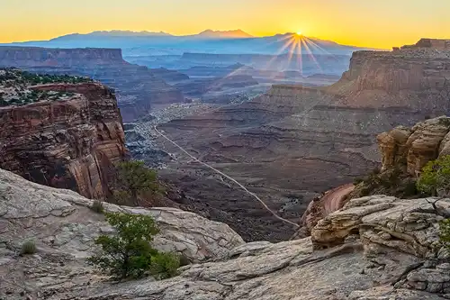 Sunrise starburst over La Sal Mountains, Island in the Sky, Canyonlands. Photo by Rick Thompson.