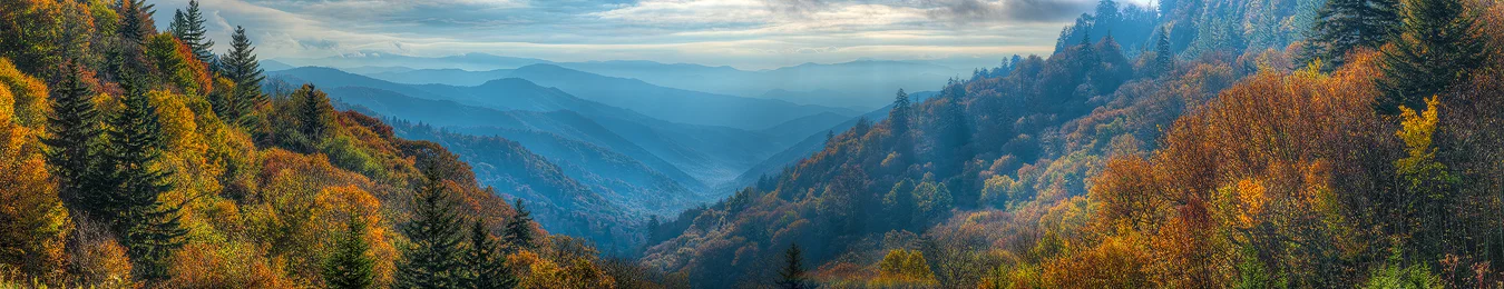 Great Smoky Mountains National Park Fall Photography Workshop with Andy Cook. Panoramic view of backlit autumn colors framing layered blue mountains, showcasing fall in the Smokies.