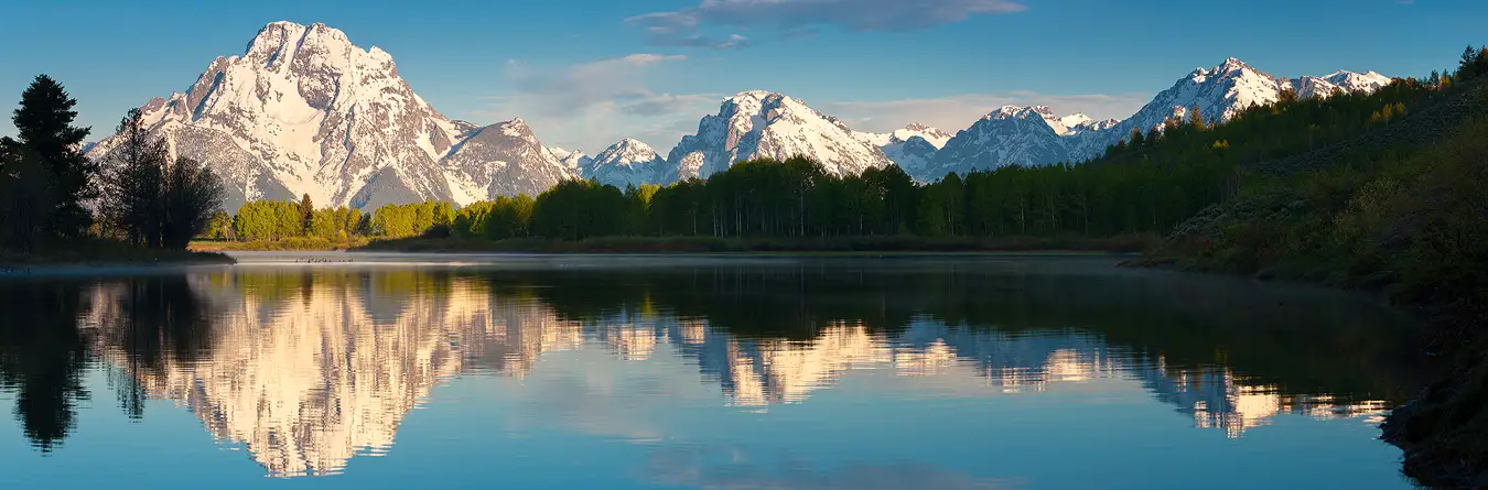Grand Teton Photography Workshop: Panoramic morning view of snow-capped Mount Moran reflecting in Oxbow Bend, Snake River. Join our June workshop to photograph these landscapes.